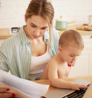 Mãe e filho usando notebook para pesquisar os documentos necessários para matrícula escolar em 2024